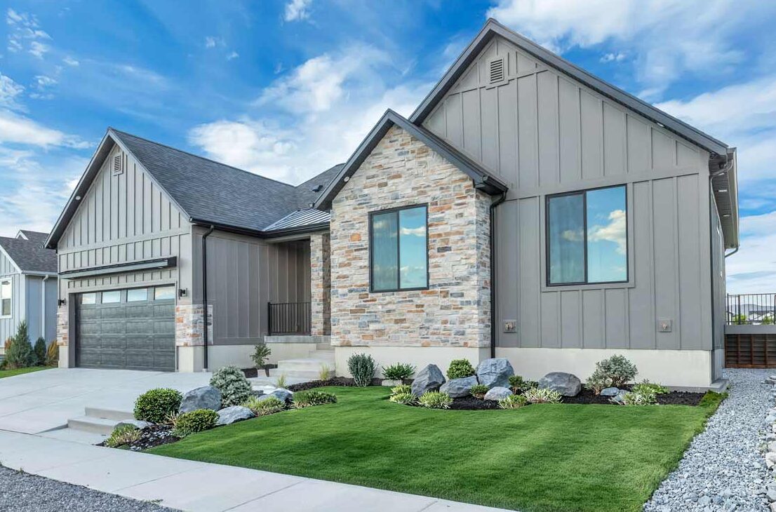 A beautifully designed modern exterior of a Narwhal home featuring clean lines, premium siding, and professional landscaping under a clear Utah sky. This image showcases the inviting curb appeal and thoughtful craftsmanship that defines our architectural style, highlighting the perfect balance between comfort and contemporary elegance.