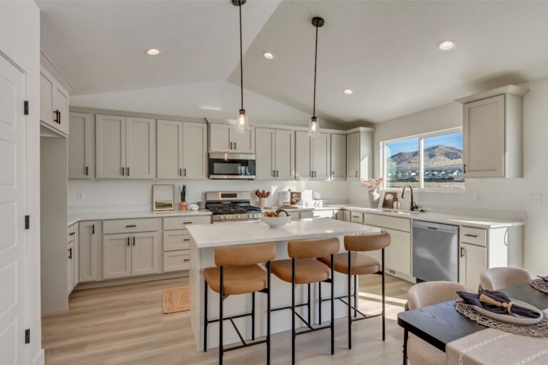 The image is a digitally altered photo of an empty kitchen with white cabinets and appliances, featuring three hanging lights above the island counter.