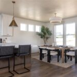 The room is white and has a dining table with chairs around it.