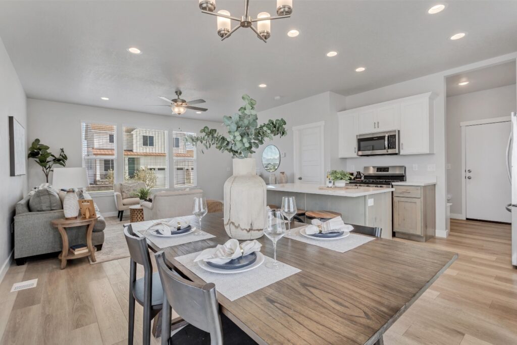 The room is white and has a dining table with chairs around it.