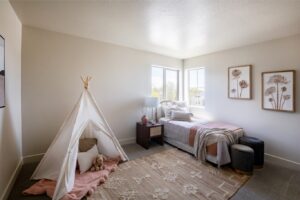 The room is white with a teepee and stuffed animal.