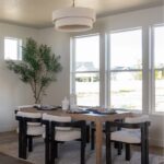 A white room with a dining table and chairs near windows.