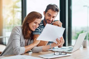 Couple looking at floorplans happily.